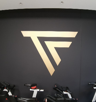 Branding – Gold-Logo auf dunkler Wand